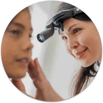 A health care provider inspecting a patient's ear