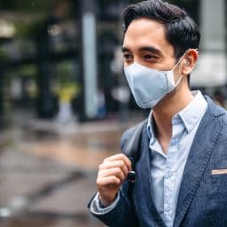 Businessman wearing pollution mask in city