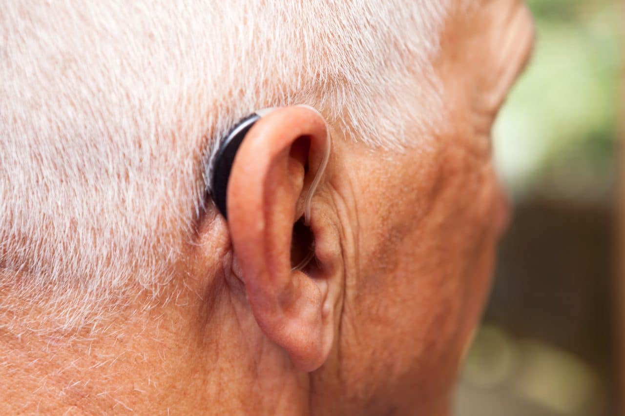 Man wearing a behind-the-ear hearing aid.