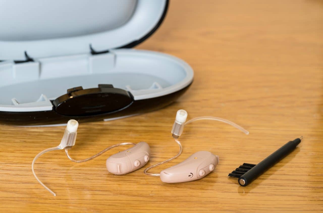 Close up of a pair of hearing aids on bedside table.