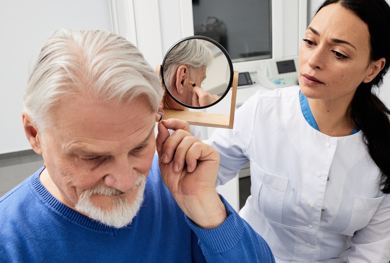 Man tries on hearing aid