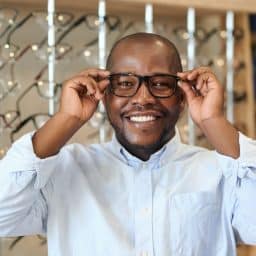 Happy man trying on glasses