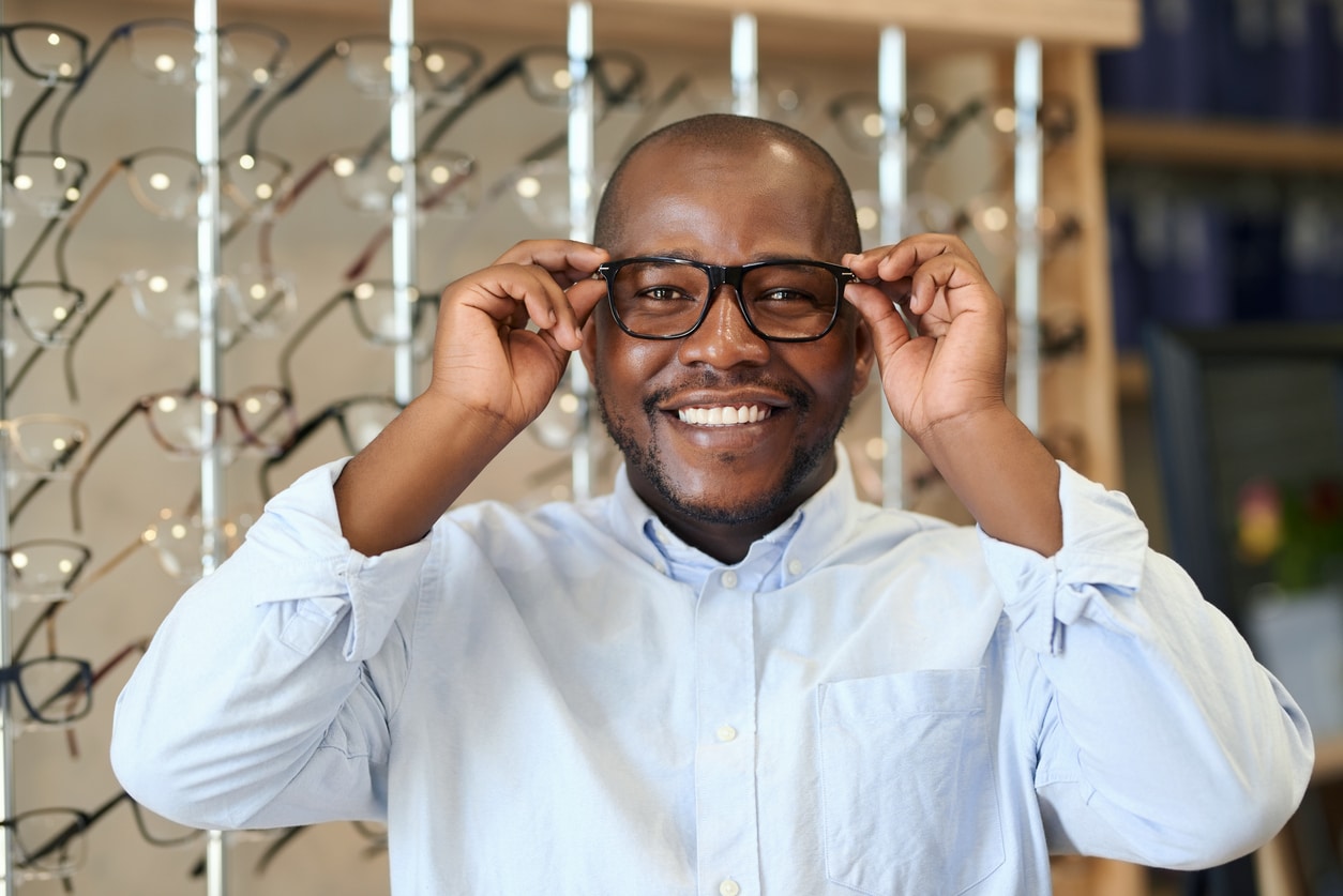 Happy man trying on glasses.