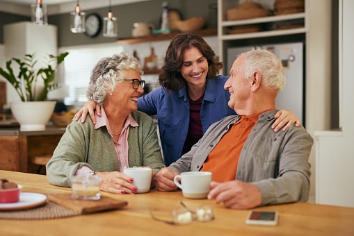 Senior father and old mother sharing tea and heartfelt conversation with daughter at home at tea time.